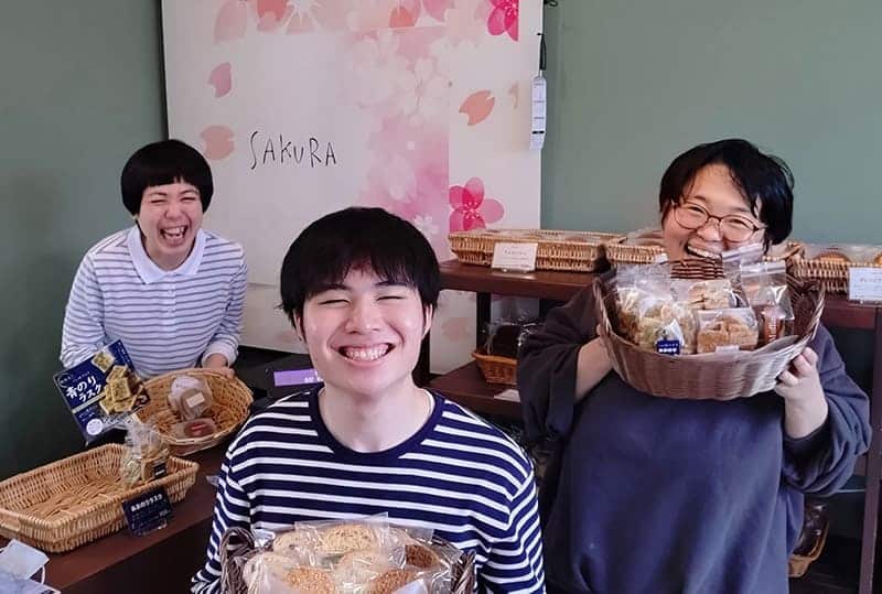 お菓子を持って笑顔の利用者