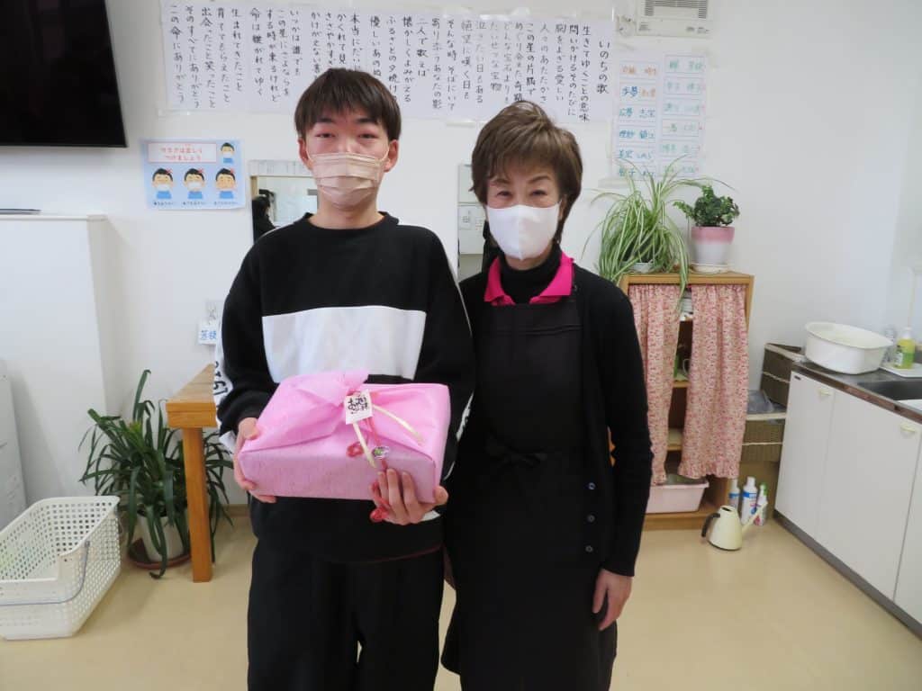 プレゼントを受け取る男性と理事長